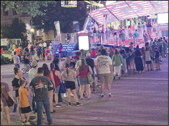 A blue and yellow tent with a sign that says “Buy or Reload Cards Here". Description generated by AI
