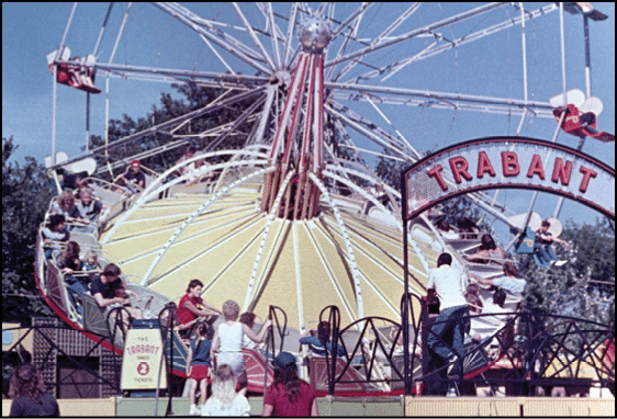 A group of people are sitting in a yellow ride at an amusement park. Description generated by AI