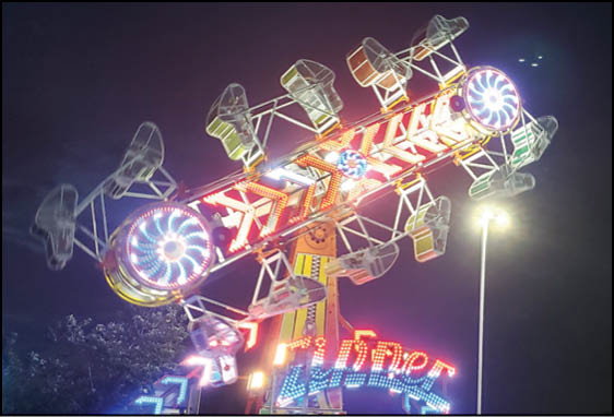 A group of people are sitting in a yellow ride at an amusement park. Description generated by AI