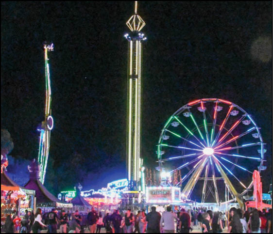 A carnival with lots of lights and rides. Description generated by AI