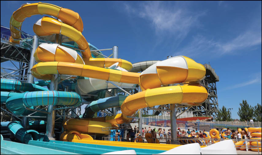 A group of people are sitting in a yellow ride at an amusement park. Description generated by AI