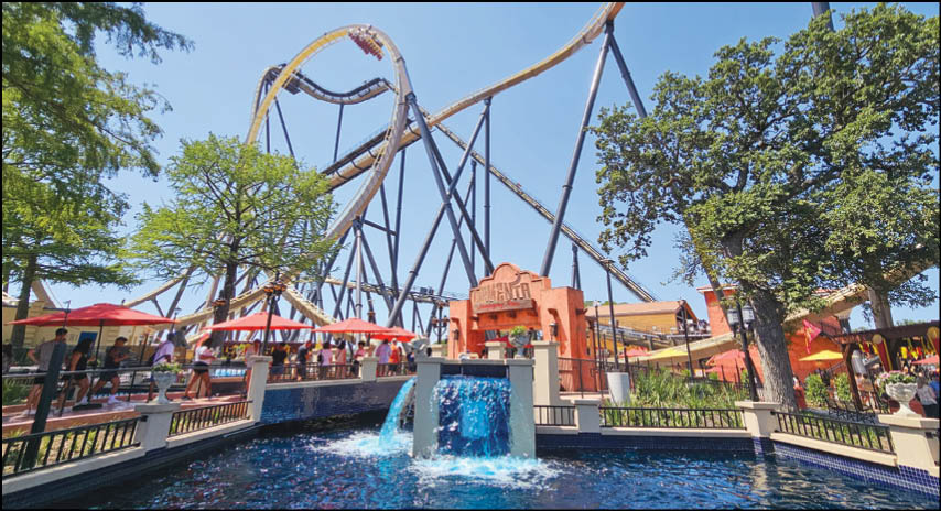A group of people are sitting in a yellow ride at an amusement park. Description generated by AI
