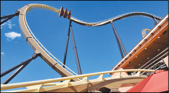 A group of people are sitting in a yellow ride at an amusement park. Description generated by AI
