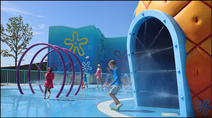 A group of people are sitting in a yellow ride at an amusement park. Description generated by AI