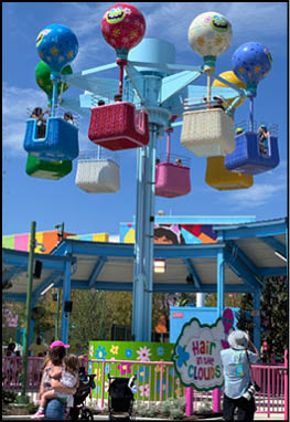 A group of people are sitting in a yellow ride at an amusement park. Description generated by AI