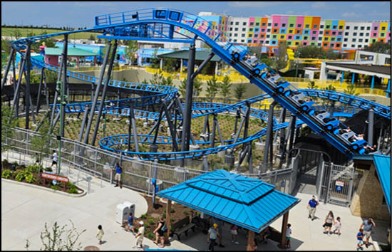 A group of people are sitting in a yellow ride at an amusement park. Description generated by AI