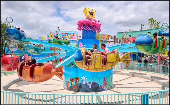 A group of people are sitting in a yellow ride at an amusement park. Description generated by AI