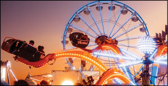 A carnival with lots of lights and rides. Description generated by AI