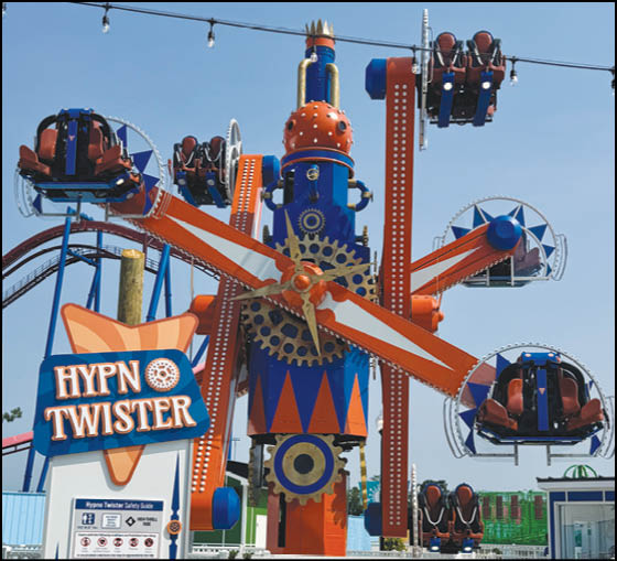 A group of people are sitting in a yellow ride at an amusement park. Description generated by AI