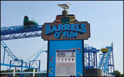 A group of people are sitting in a yellow ride at an amusement park. Description generated by AI