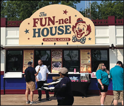 A group of people are sitting in a yellow ride at an amusement park. Description generated by AI