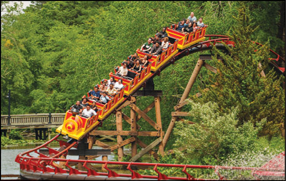 A group of people are sitting in a yellow ride at an amusement park. Description generated by AI