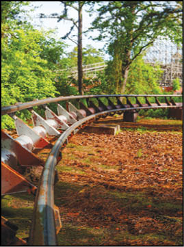 A group of people are sitting in a yellow ride at an amusement park. Description generated by AI