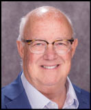A man wearing a white shirt and black jacket. Description generated by AI