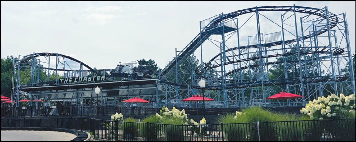 A group of people are sitting in a yellow ride at an amusement park. Description generated by AI