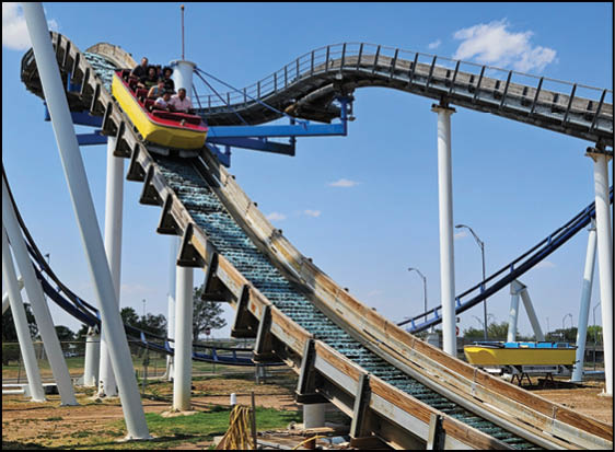 A group of people are sitting in a yellow ride at an amusement park. Description generated by AI