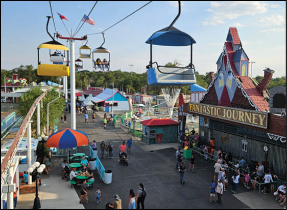A group of people are sitting in a yellow ride at an amusement park. Description generated by AI