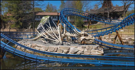 A group of people are sitting in a yellow ride at an amusement park. Description generated by AI
