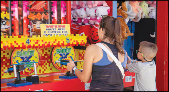 A group of people are sitting in a yellow ride at an amusement park. Description generated by AI