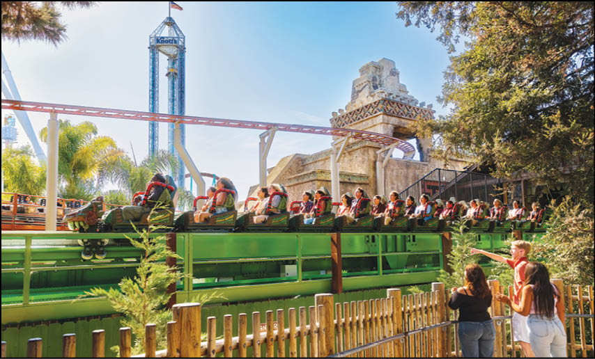 A group of people are sitting in a yellow ride at an amusement park. Description generated by AI