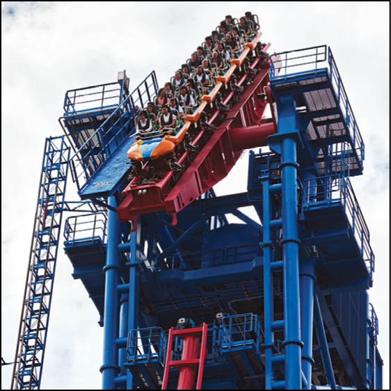 A group of people are sitting in a yellow ride at an amusement park. Description generated by AI