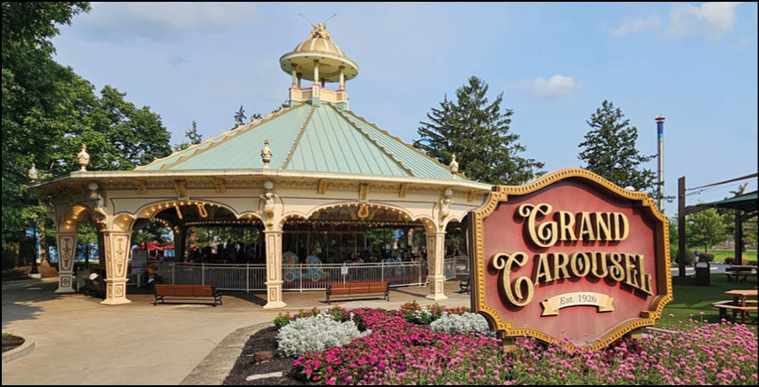 A group of people are sitting in a yellow ride at an amusement park. Description generated by AI