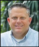 A man wearing a white shirt and black jacket. Description generated by AI