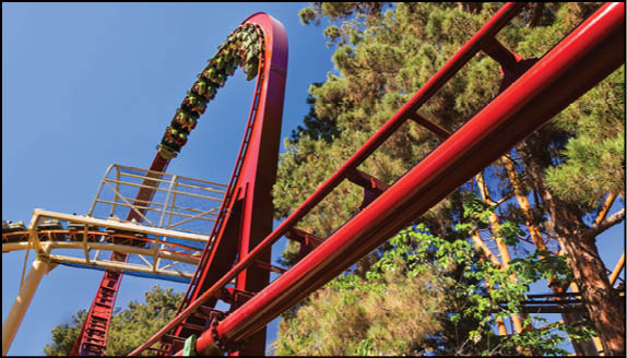 A group of people are sitting in a yellow ride at an amusement park. Description generated by AI