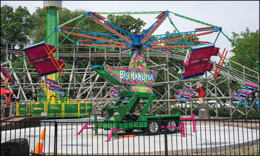 A group of people are sitting in a yellow ride at an amusement park. Description generated by AI