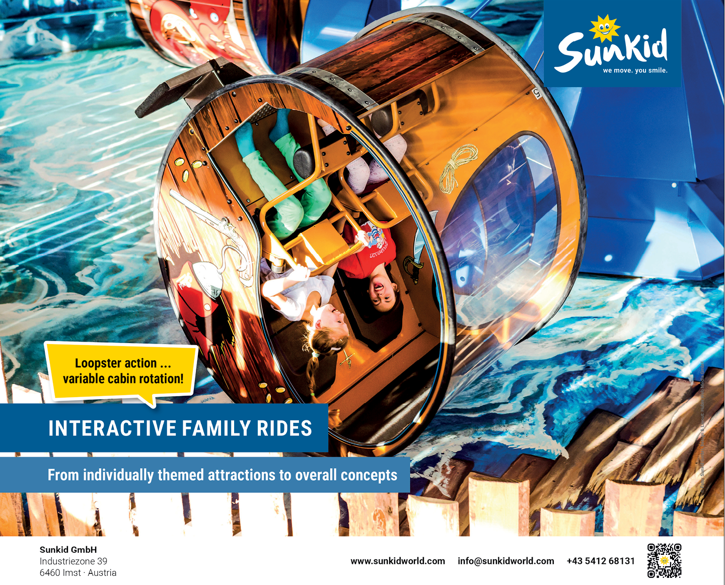 Two children are enjoying a rotating cabin ride designed as an interactive family attraction with a wooden barrel-like structure and clear windows. Description generated by AI